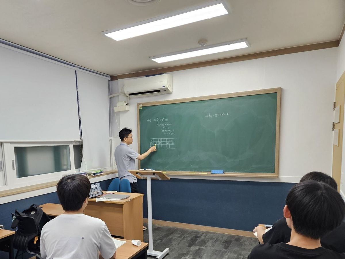 칠판에 함수의 증감표를 판서하는 고등부 수업